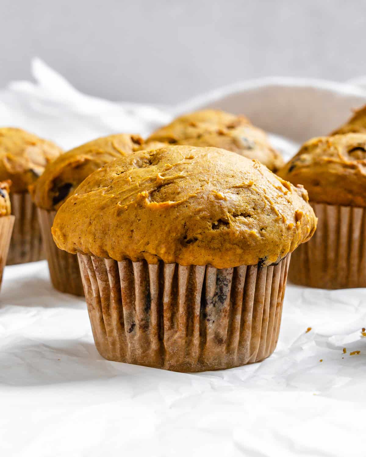 completed Vegan Pumpkin Chocolate Chip Muffins on a white surface