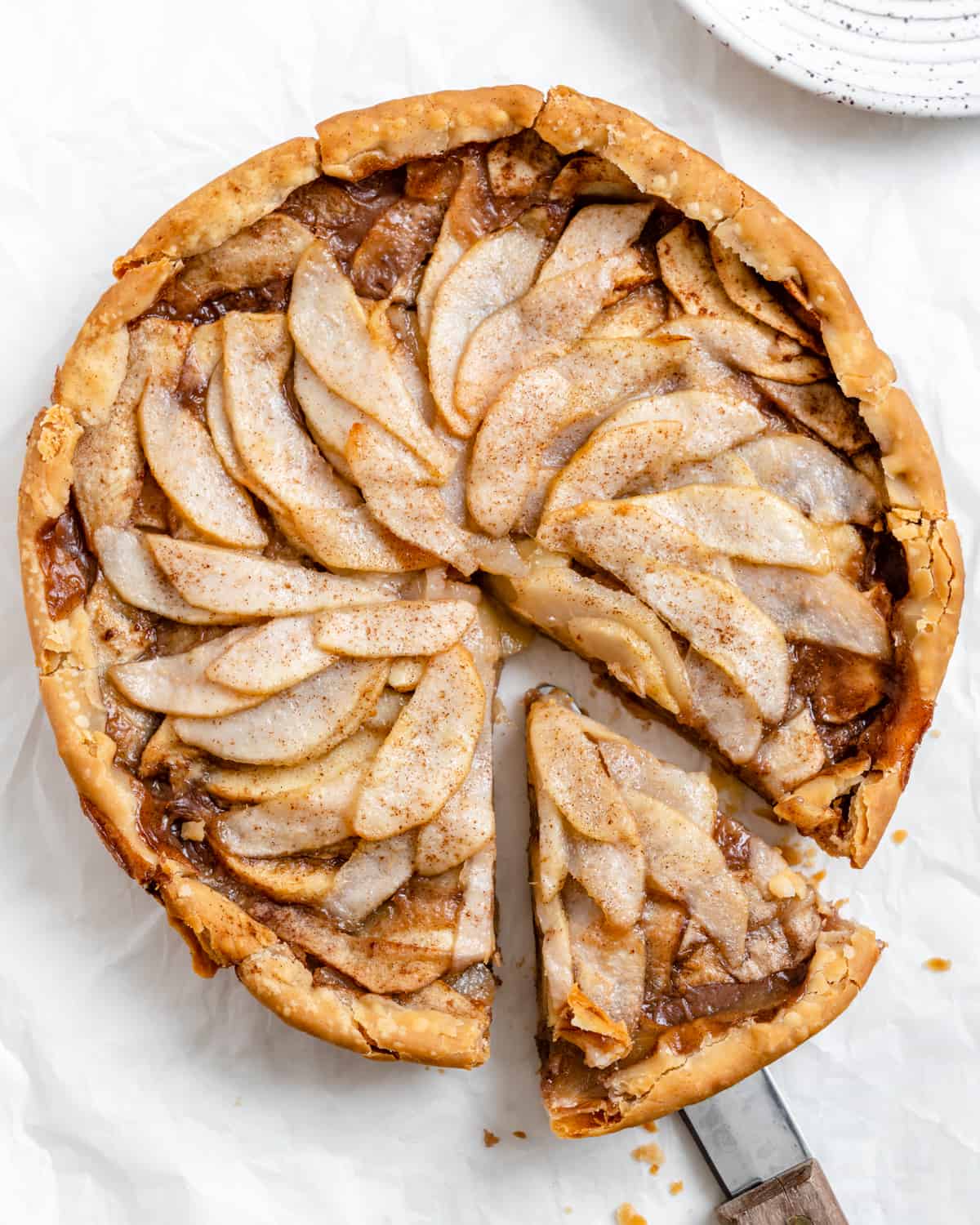 completed Easy Apple Pear Pie with a slice cut out against a white surface