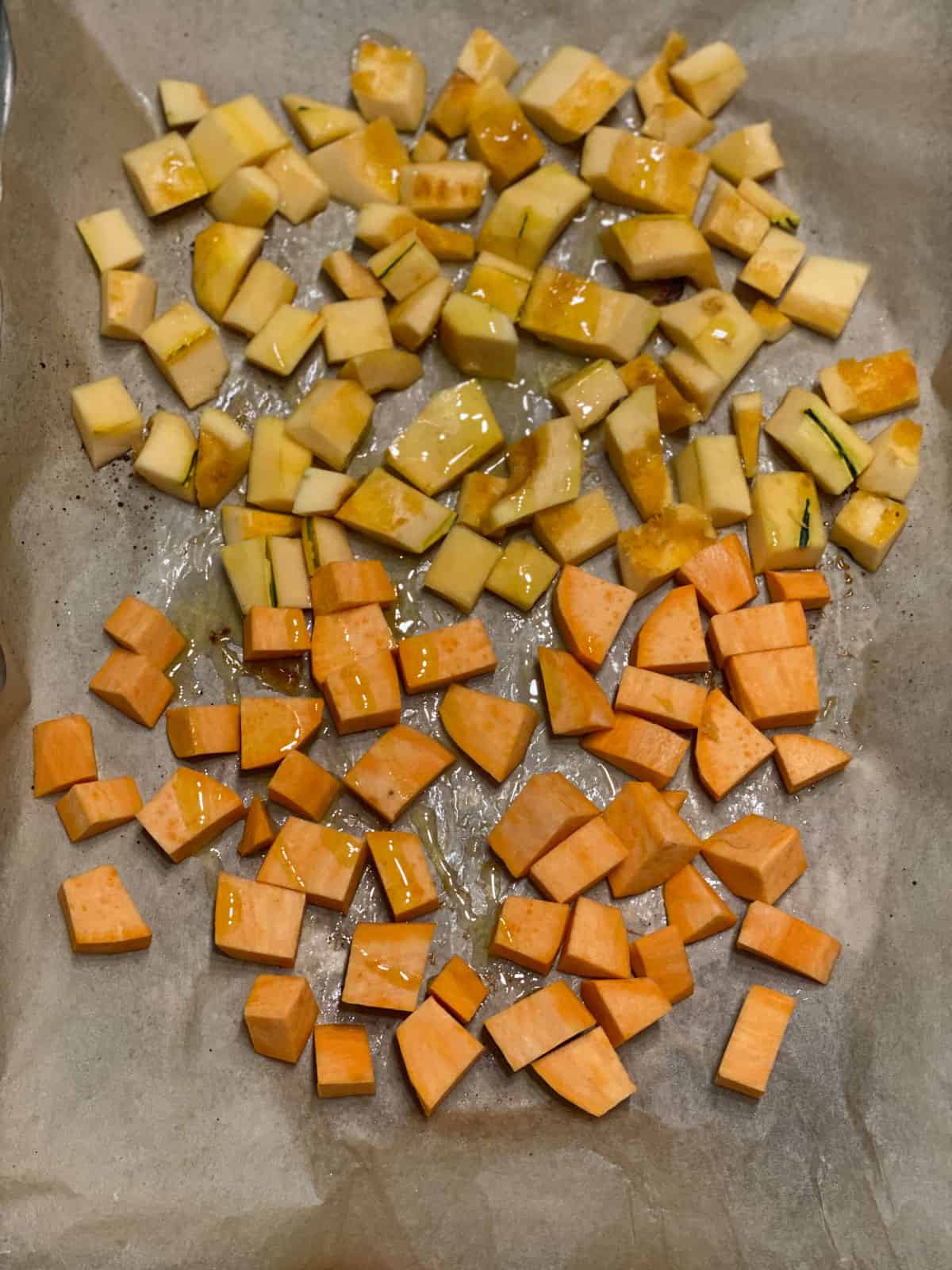 process shot of roasting squash and sweet potato in baking tray