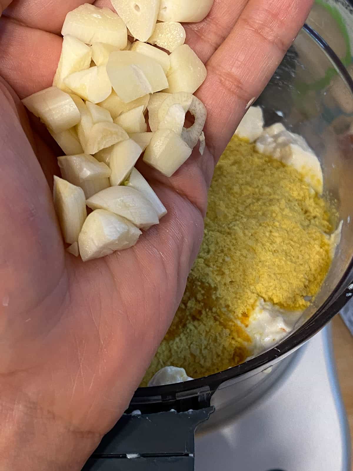 process shot of adding garlic to blender