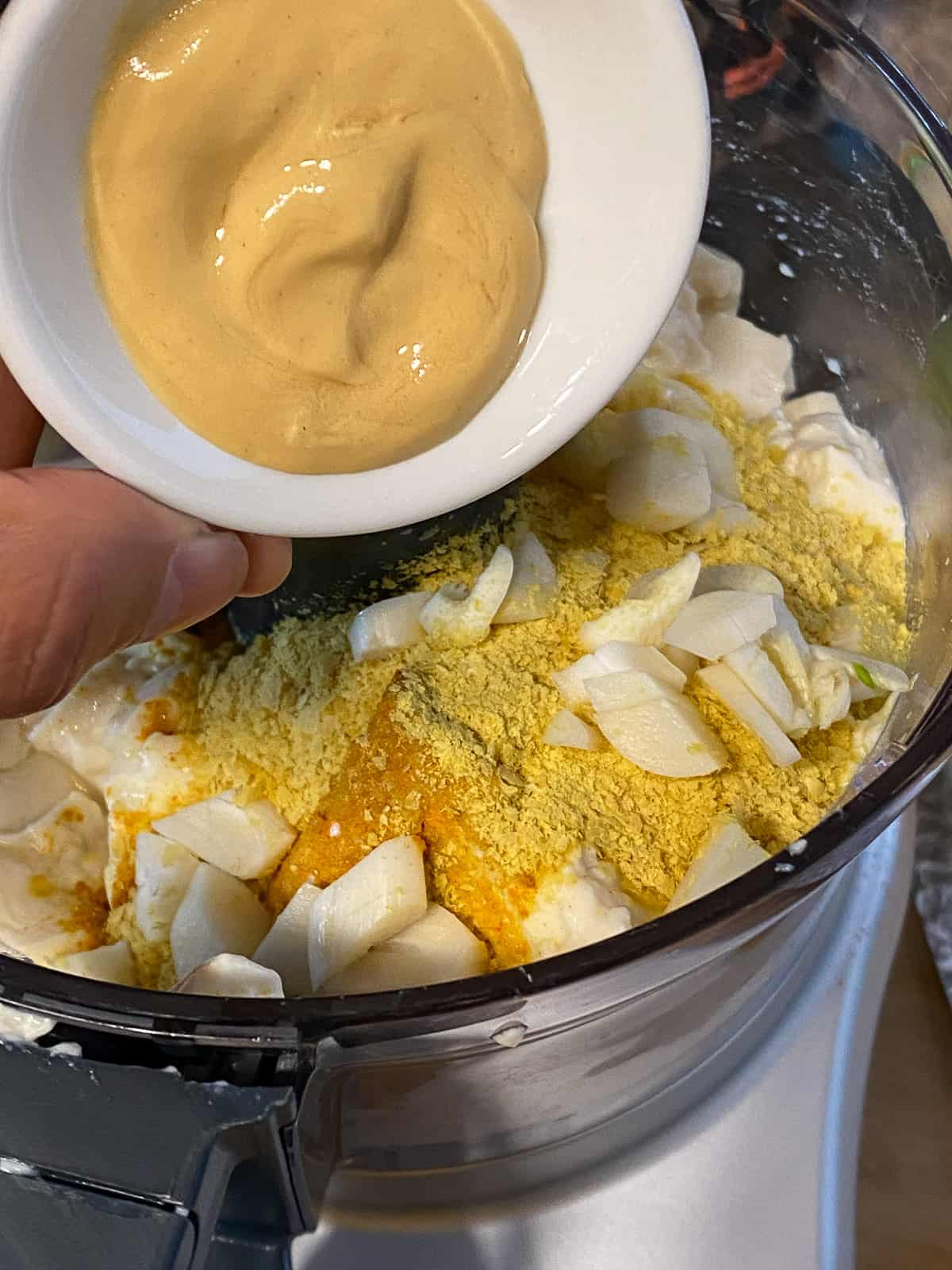 process shot of adding dijon mustard to blender