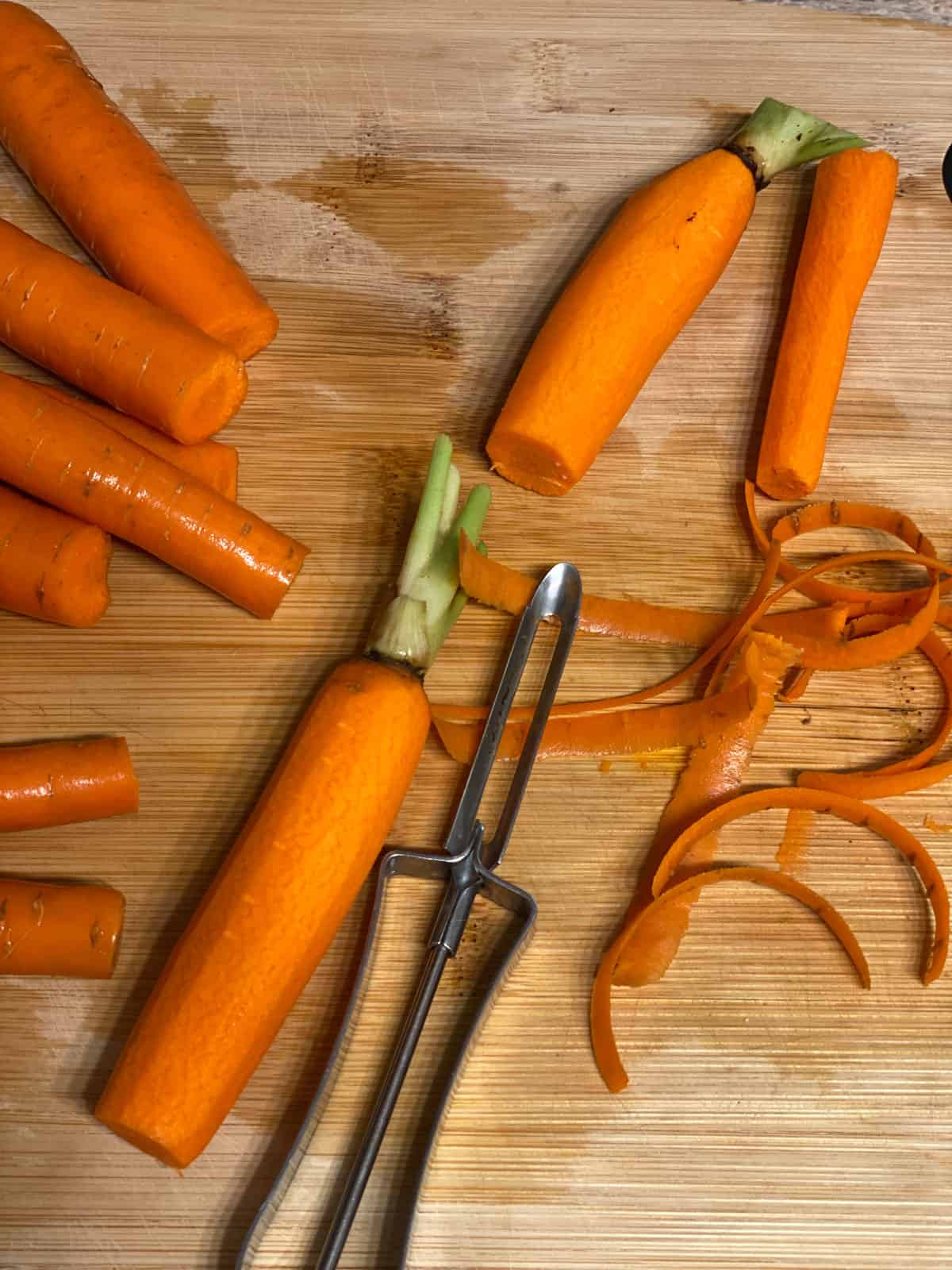 process shot of peeling carrots against cutting board