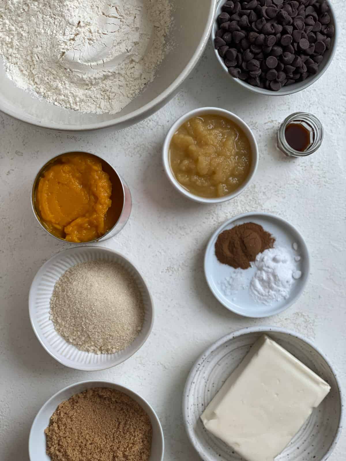 ingredients for Vegan Pumpkin Chocolate Chip Cookies measured out against a white surface
