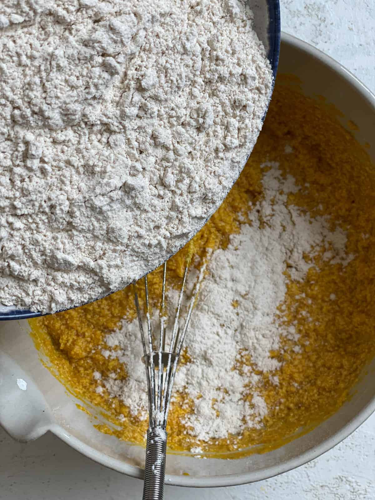 process shot of adding flour to bowl of ingredients