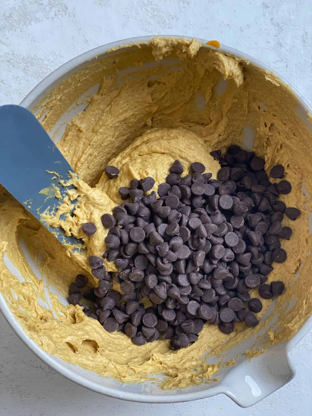 process shot of adding vegan chocolate chips to batter