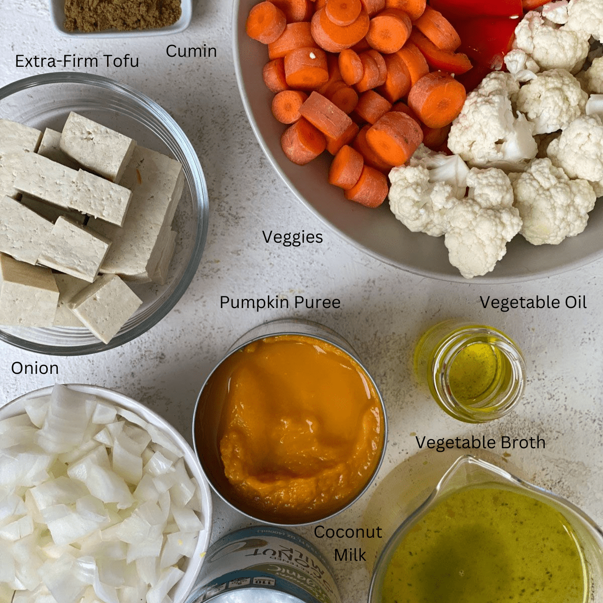 ingredients for pumpkin curry measured out against a white surface