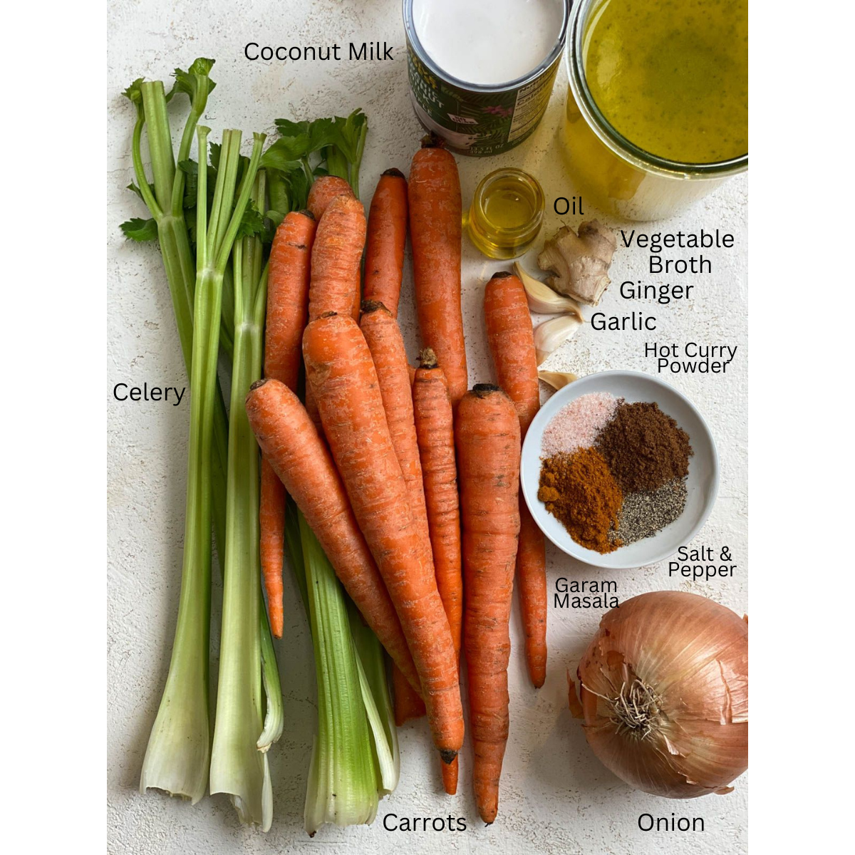 ingredients for Spicy Carrot Soup measured out against a white surface