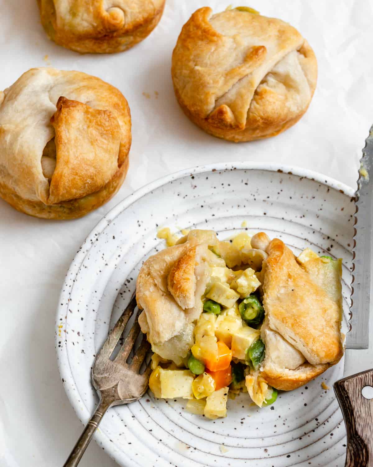 plated Mini Vegan Pot Pie on a plate with pies scattered in the background