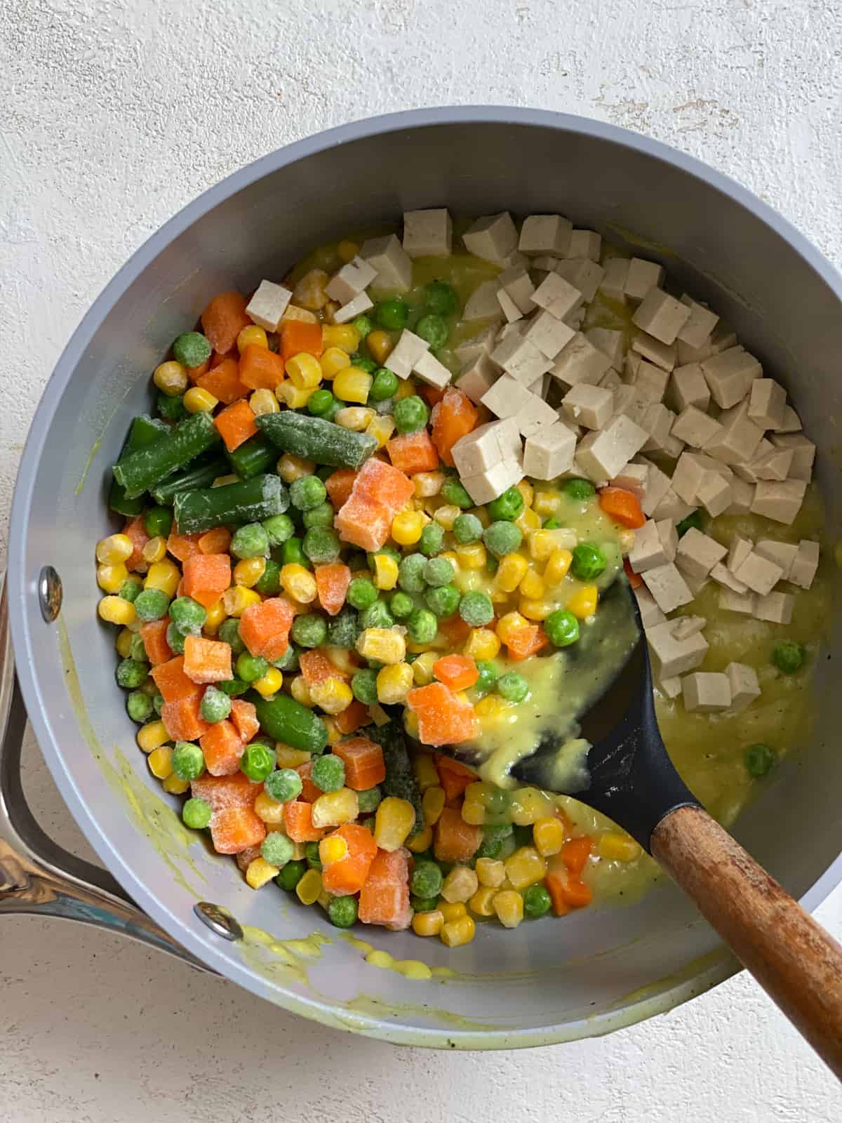 process shot of mixing ingredients for mini vegan pot pies in a bowl