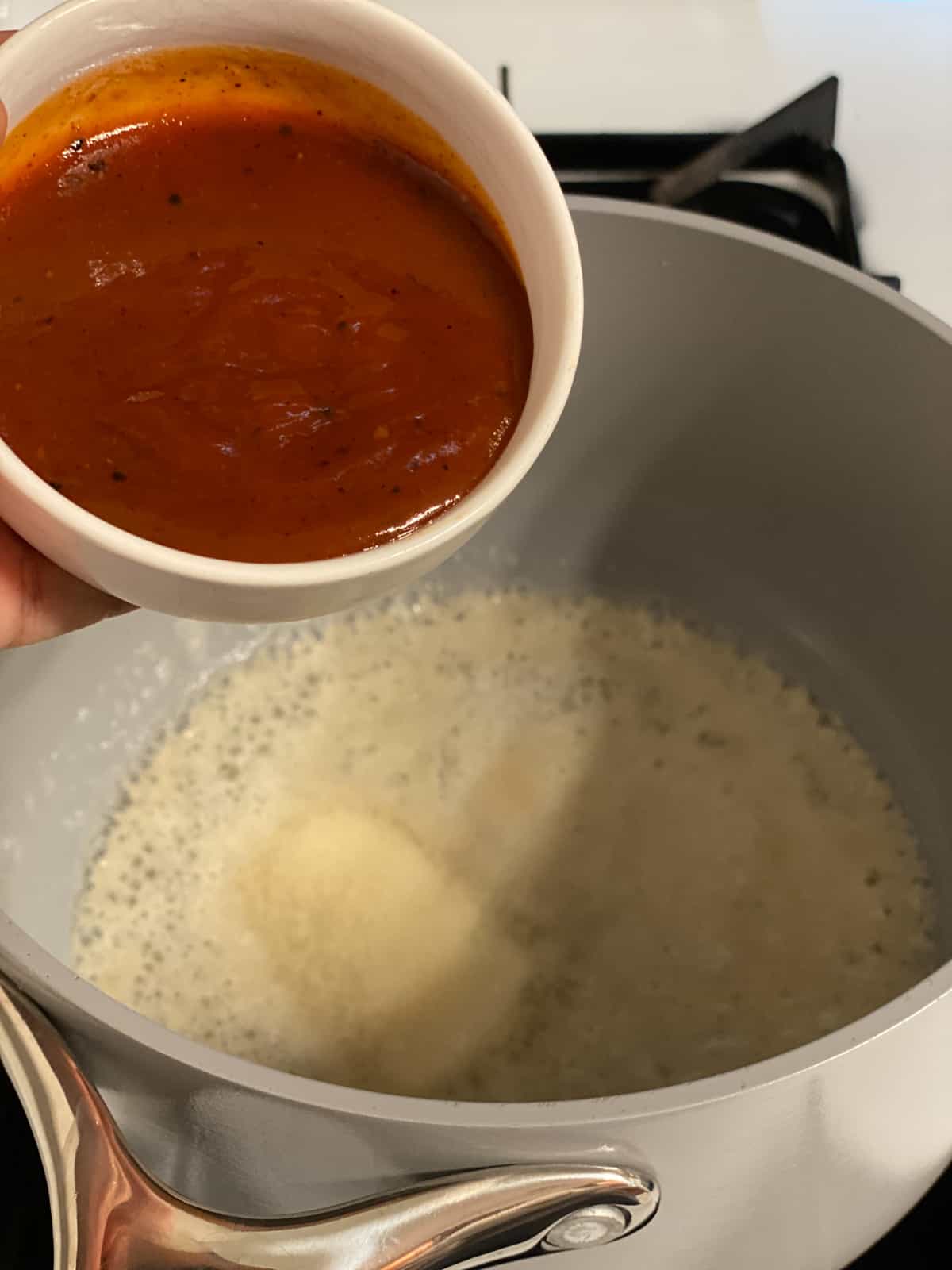 process shot of adding hot sauce to pan