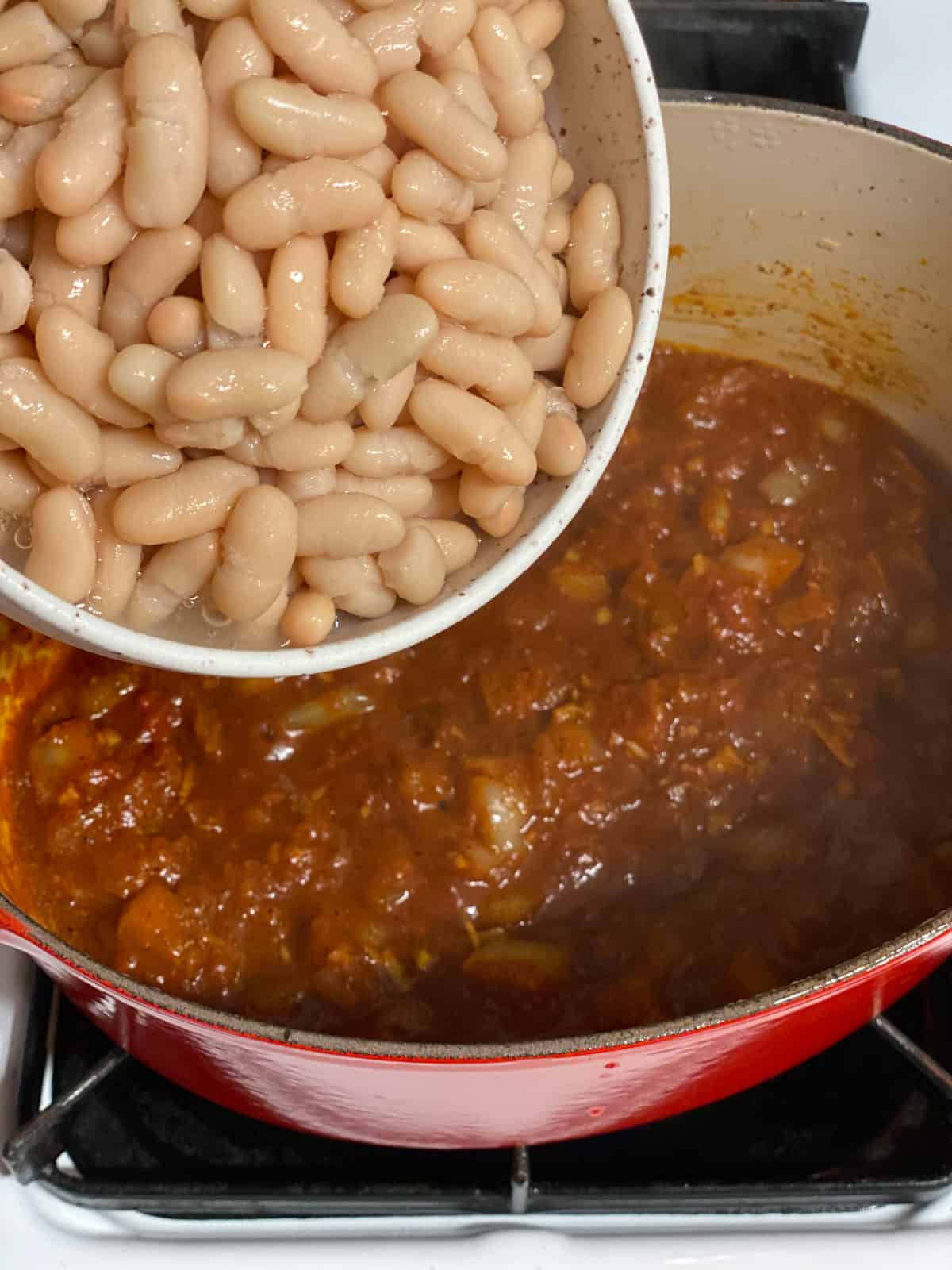 process shot of adding white beans to pan