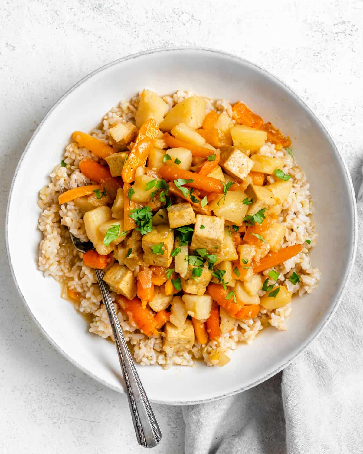 completed Slow Cooker Red Thai Curry with Tofu plated in a white dish against a white background