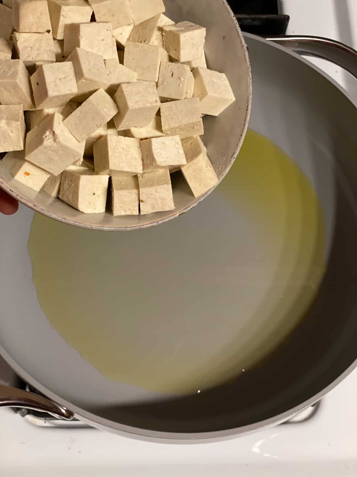 process shot of adding tofu to pan