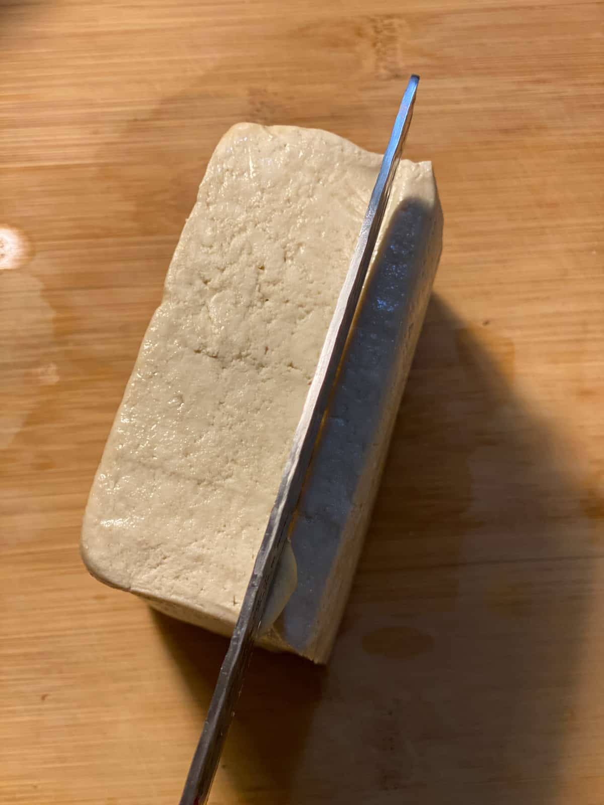 proces shot of slicing tofu block