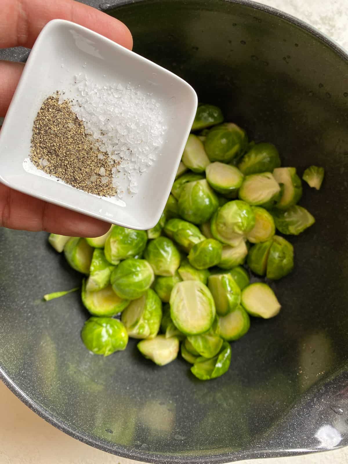 process shot of adding salt and pepper to pan