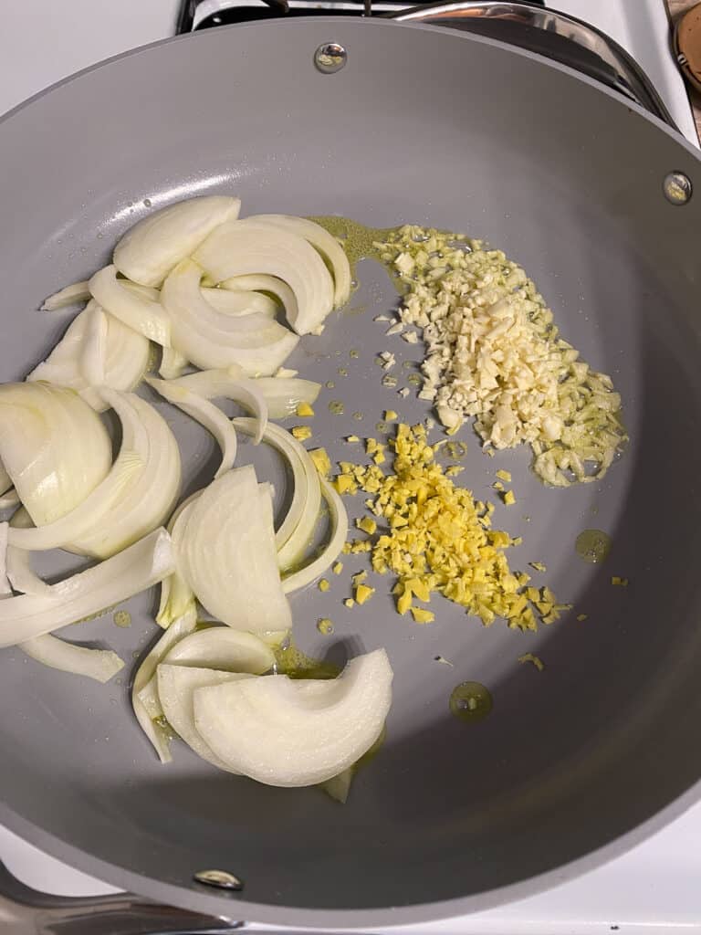 διαδικασία πλάνο του κρεμμυδιού τζίντζερ και το σκόρδο που μαγειρεύονται στο τηγάνι