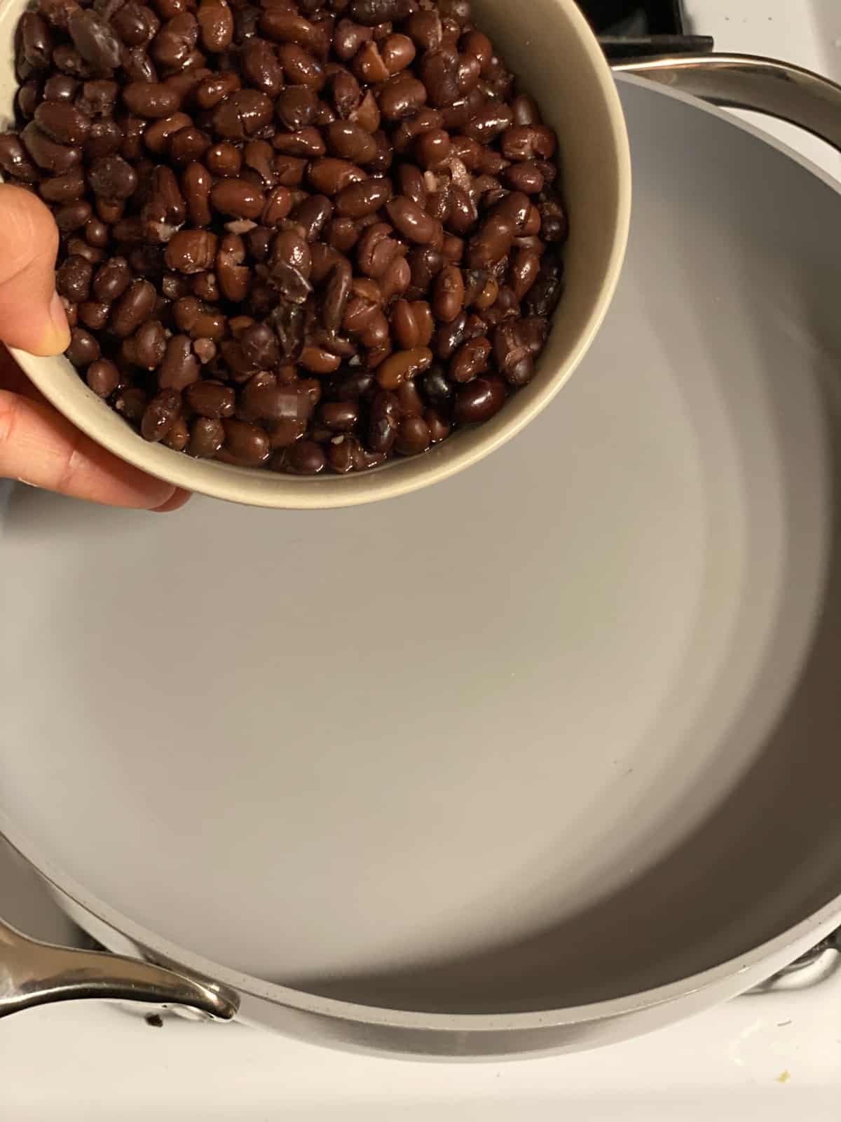 process shot of adding beans to a pan