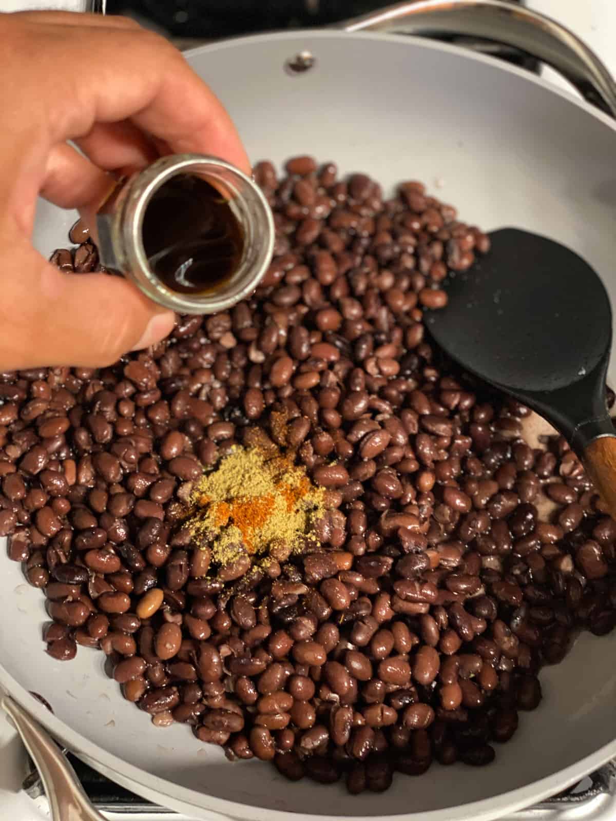 process shot of adding soy sauce to pan