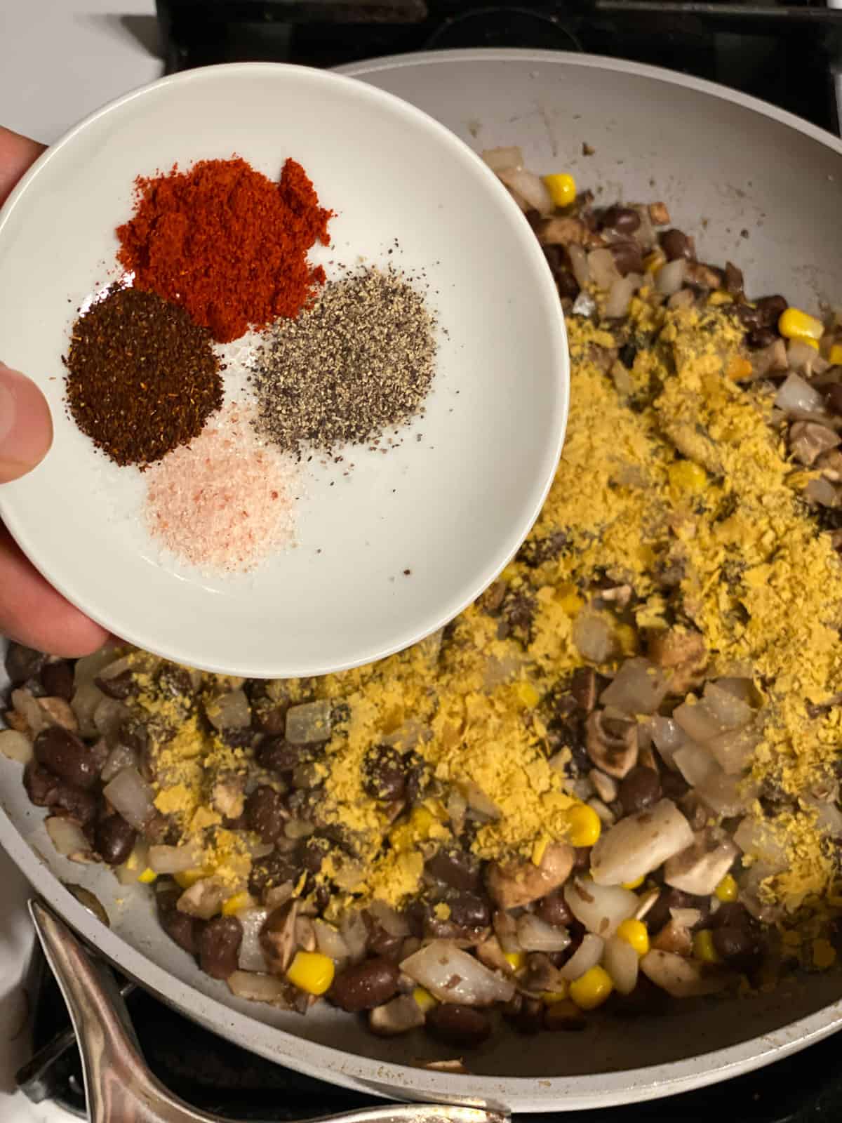 process shot of spices being added to bowl