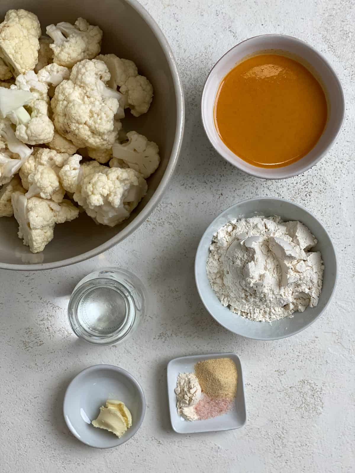 ingredients for Vegan Buffalo Cauliflower Wings [Baked + Air Fried] measured out against a white surface