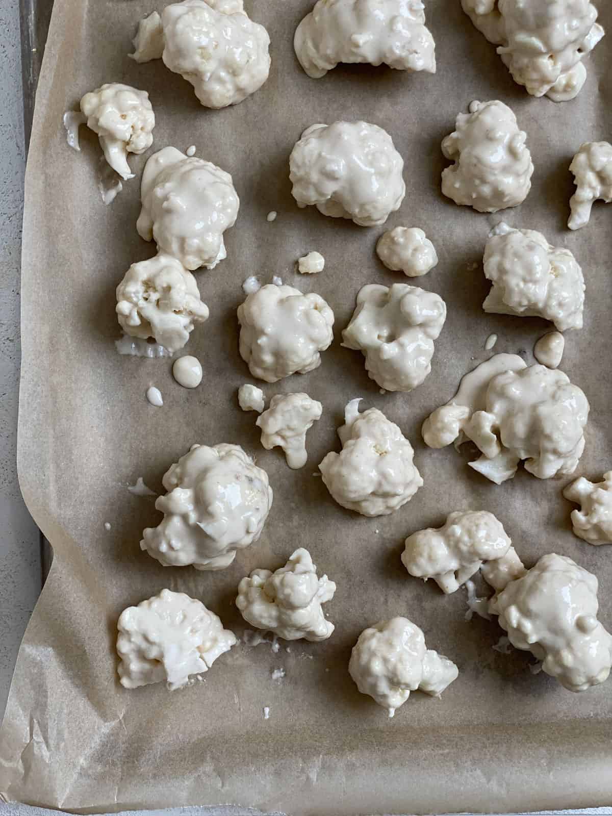 process shot of adding cauliflower to baking sheet