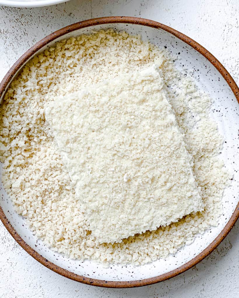 process shot of dipping tofu into panko-style bread crumbs