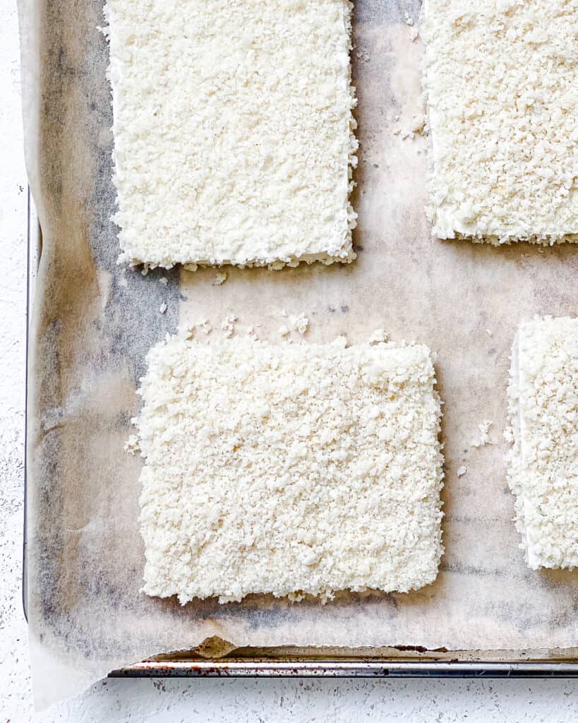 Process shot of tofu slices being added to the baking sheet