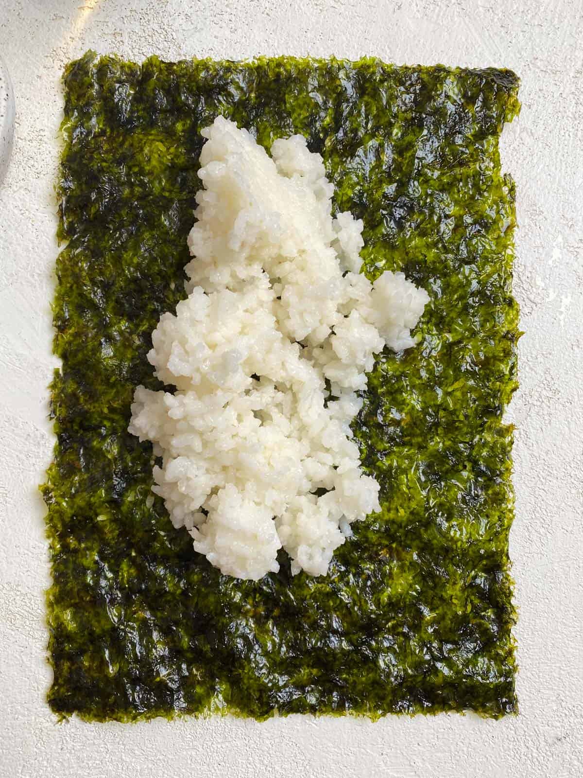 process shot of adding sushi rice to seaweed
