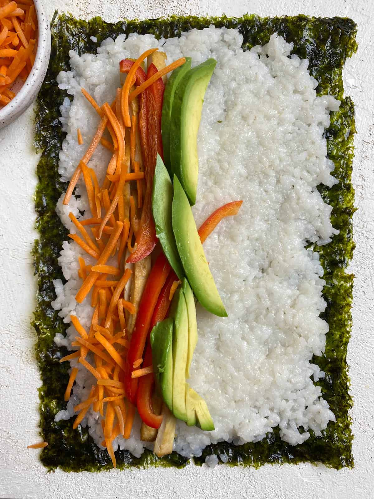 process shot of layering veggies on sushi and seaweed