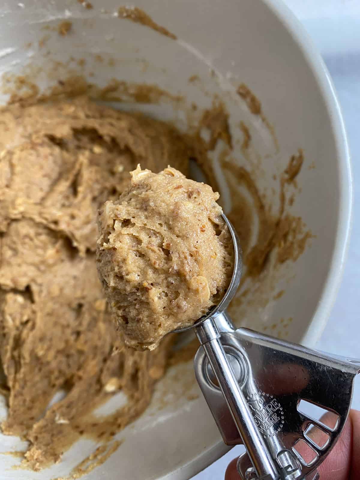 process shot of spooning out peanut butter mixture from bowl