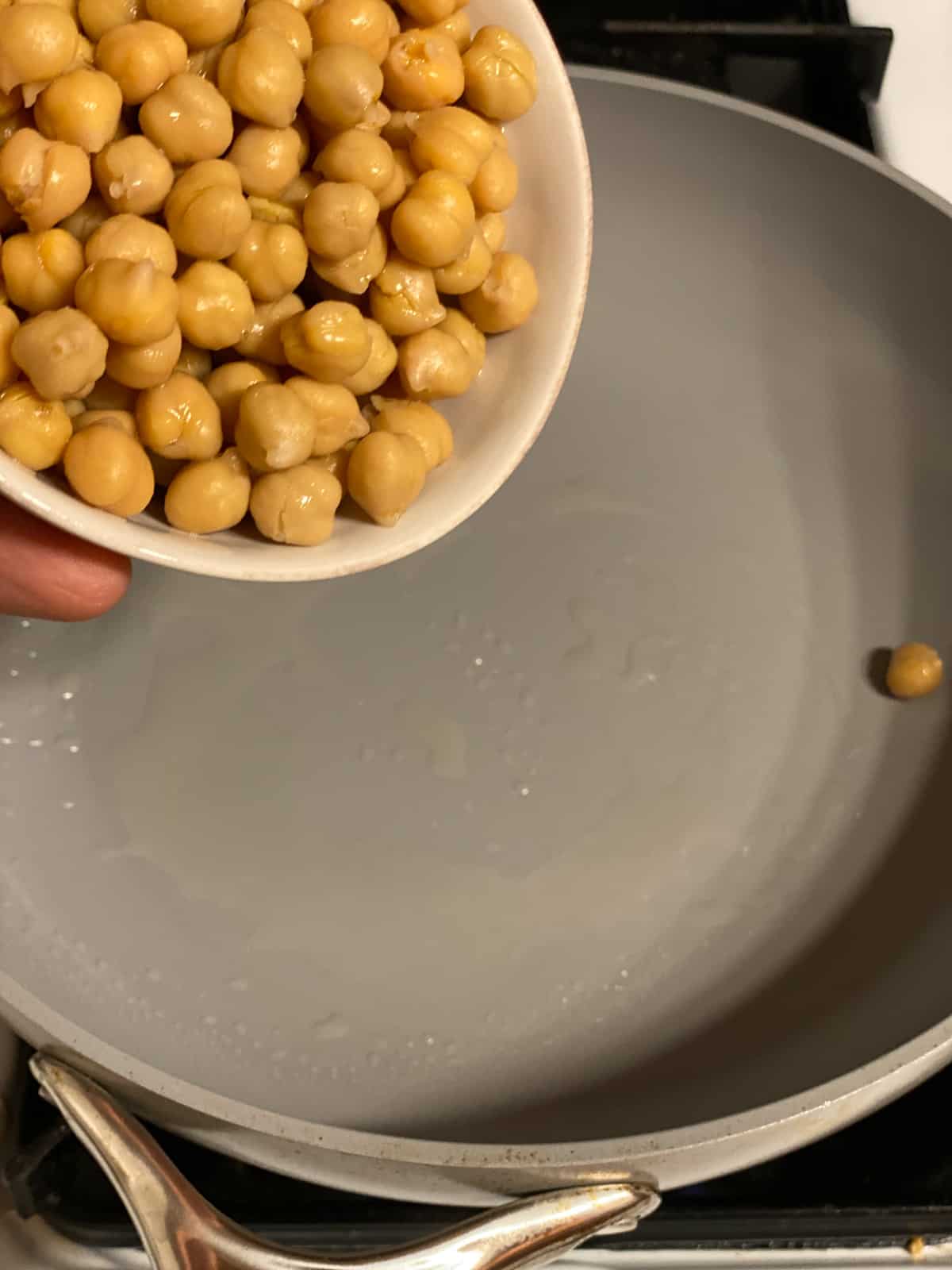 process shot of adding chickpeas to pan