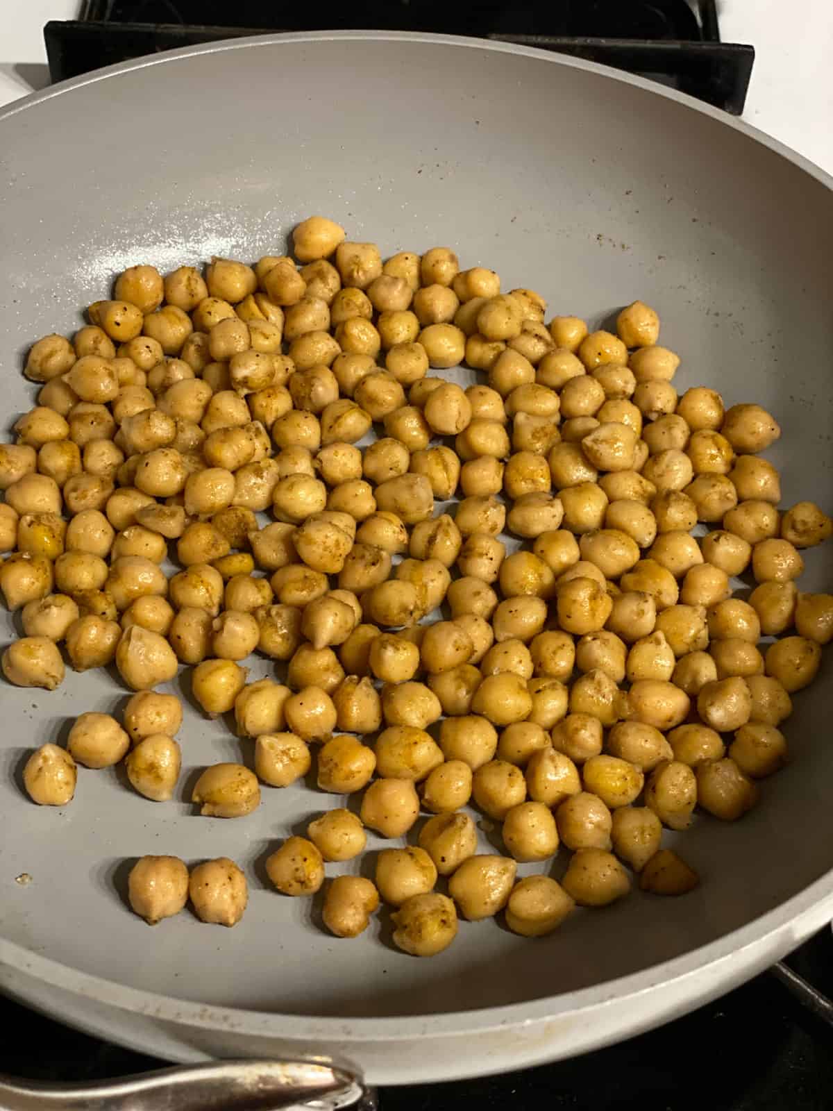 process shot of chickpeas being cooked in pan