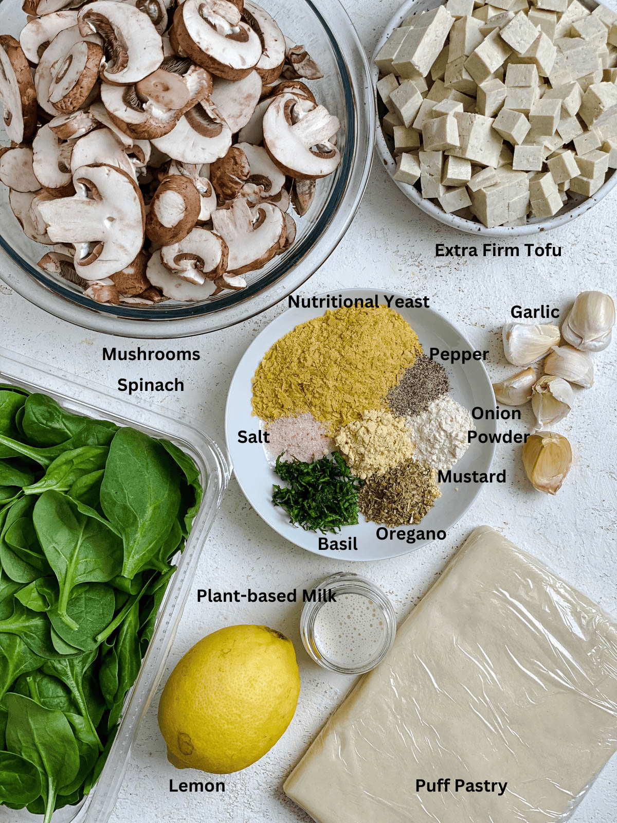 Ingredients for Spinach Mushroom Pockets measured out on a white surface. 