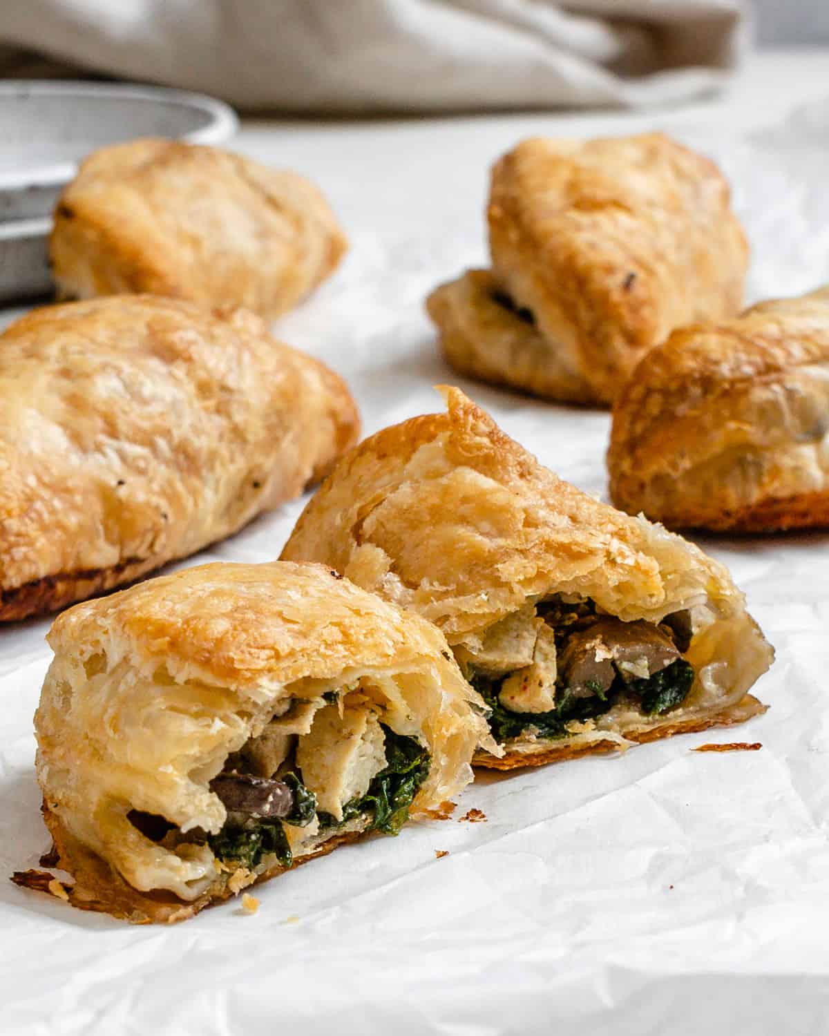 several completed Spinach and Mushroom Puffs [Vegan Hand Pies] ،tered on a white surface