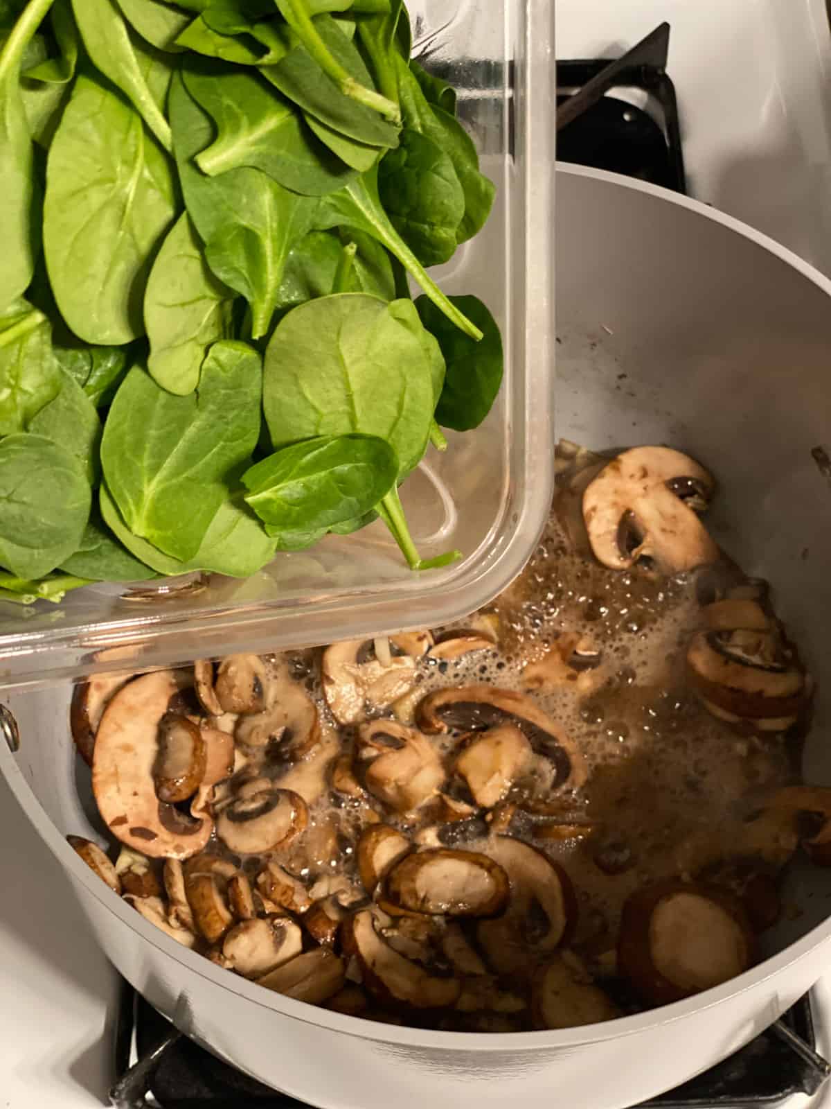 process shot of adding spinach to pan