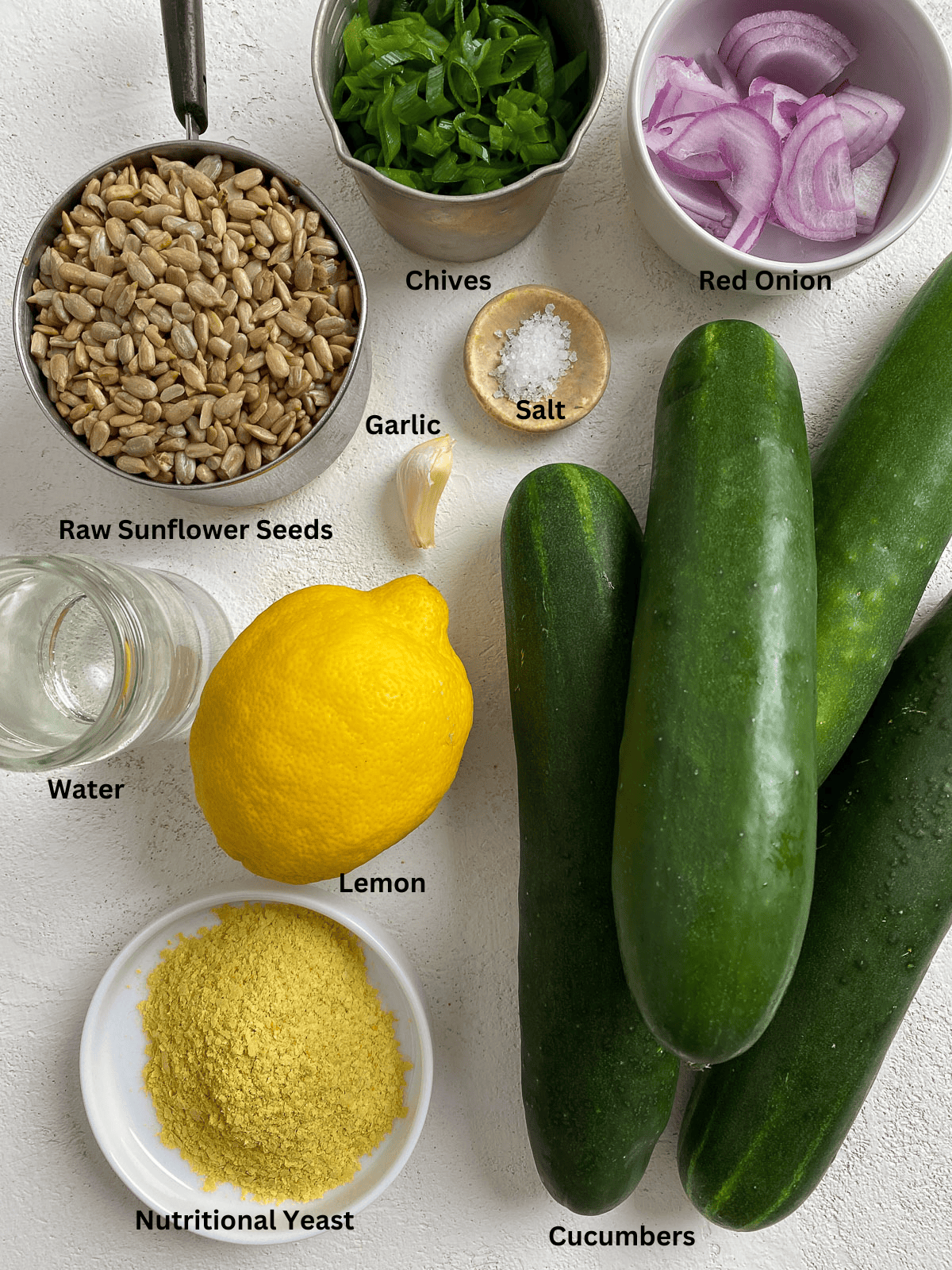 Ingredients for Easy Cucumber Bites with Sunflower Chive Cream Cheese measured out on a white surface.