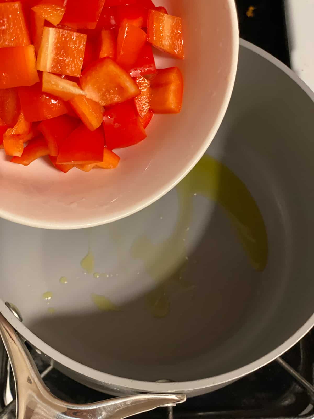 process shot of adding red bell pepper to pan