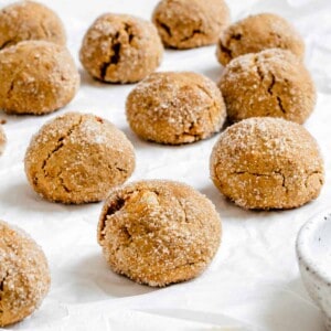 several completed Triple Ginger Vegan Ginger Cookies [Gingersnaps] on a white surface