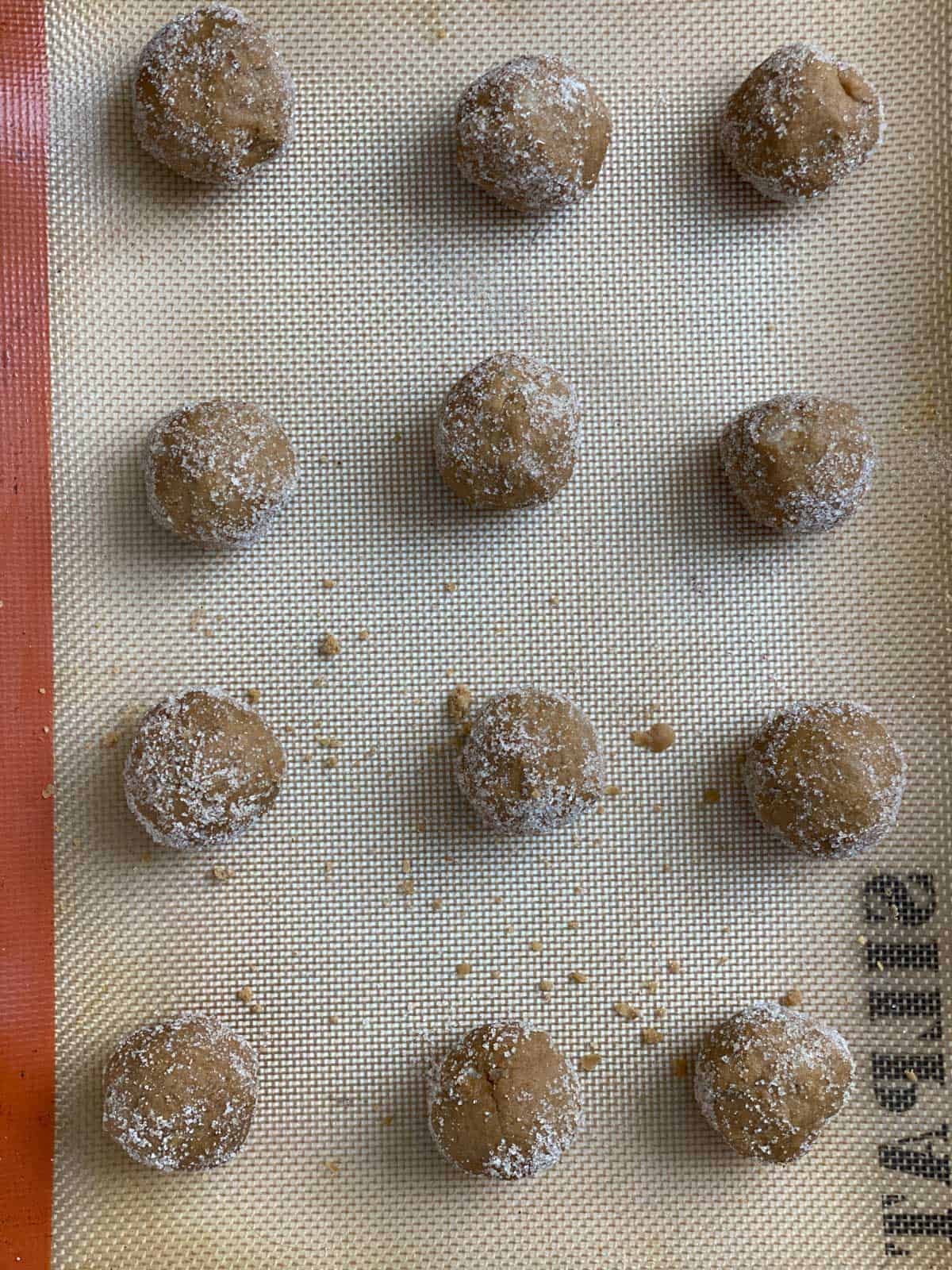several pre baked Triple Ginger Vegan Cookies [Gingersnaps] on a baking tray