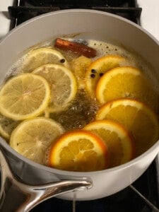 lemon cinnamon ginger tea simmering in a saucepan on the stove