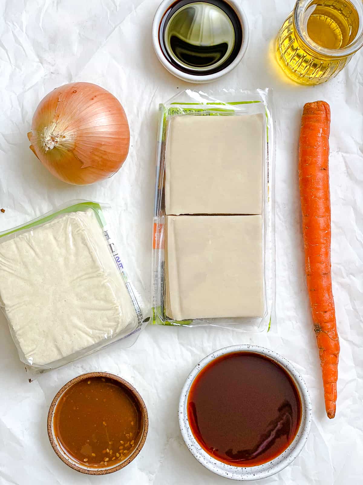 Zutaten für knusprige Wontons mit Tofu-Gemüse, gemessen auf einer weißen Fläche