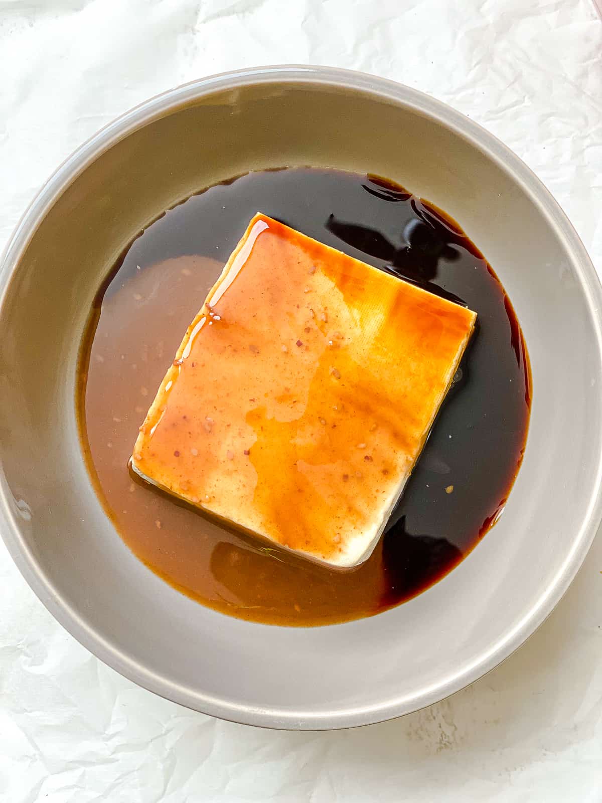 Prozessaufnahme des Hinzufügens von Tofu zu einer Schüssel Sauce