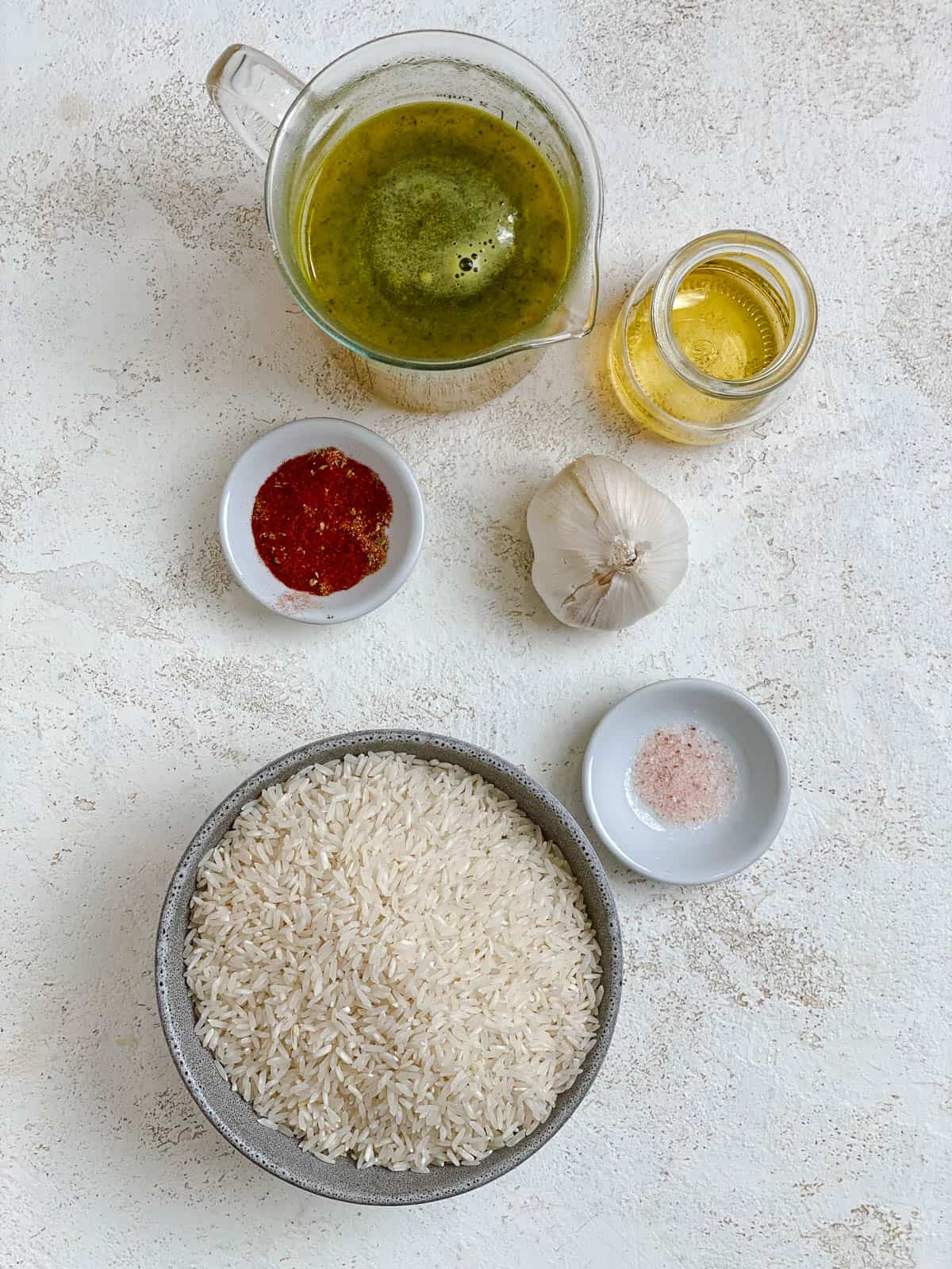 ingredients for Garlic Rice [Spanish Yellow Rice] measured out against a white surface