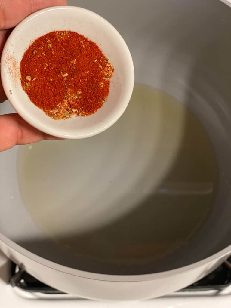 process shot of adding achiote powder to pan