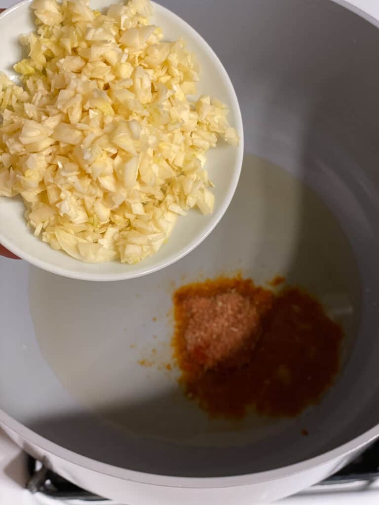 process shot of adding garlic to pan
