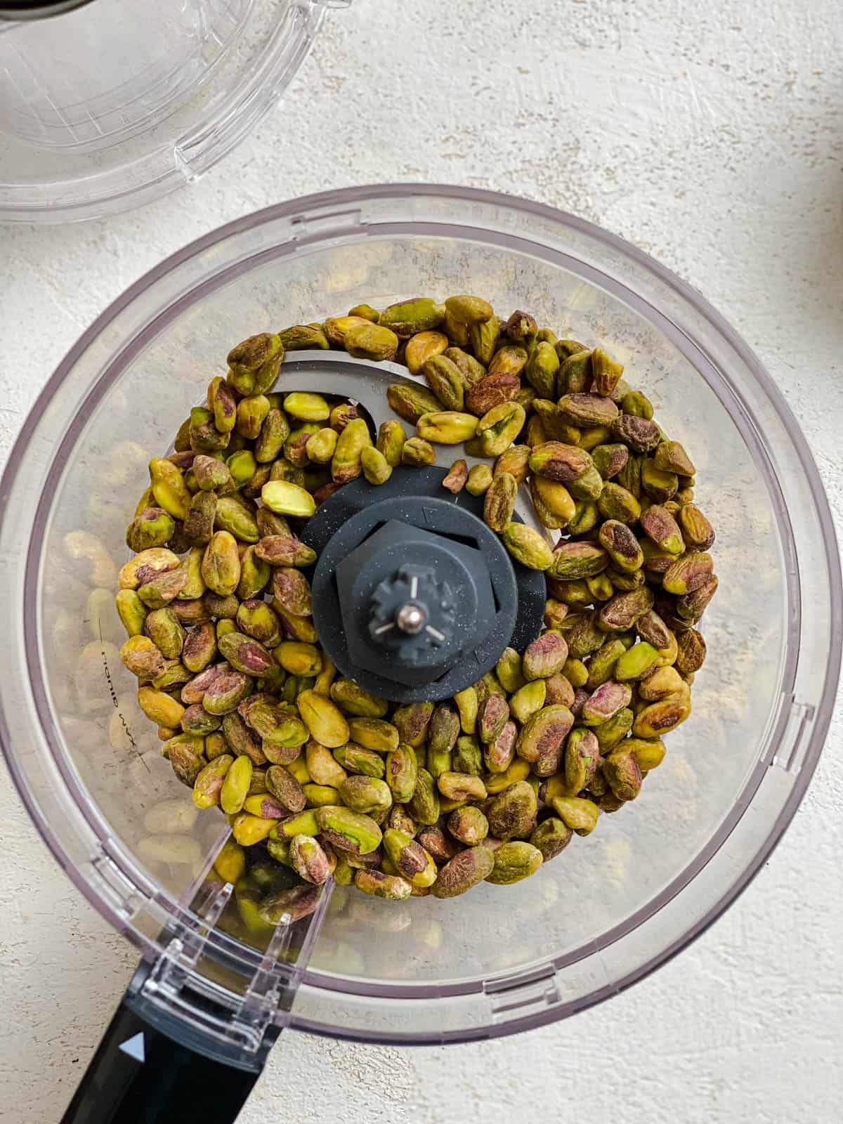 process shot of pistachios added to food processor