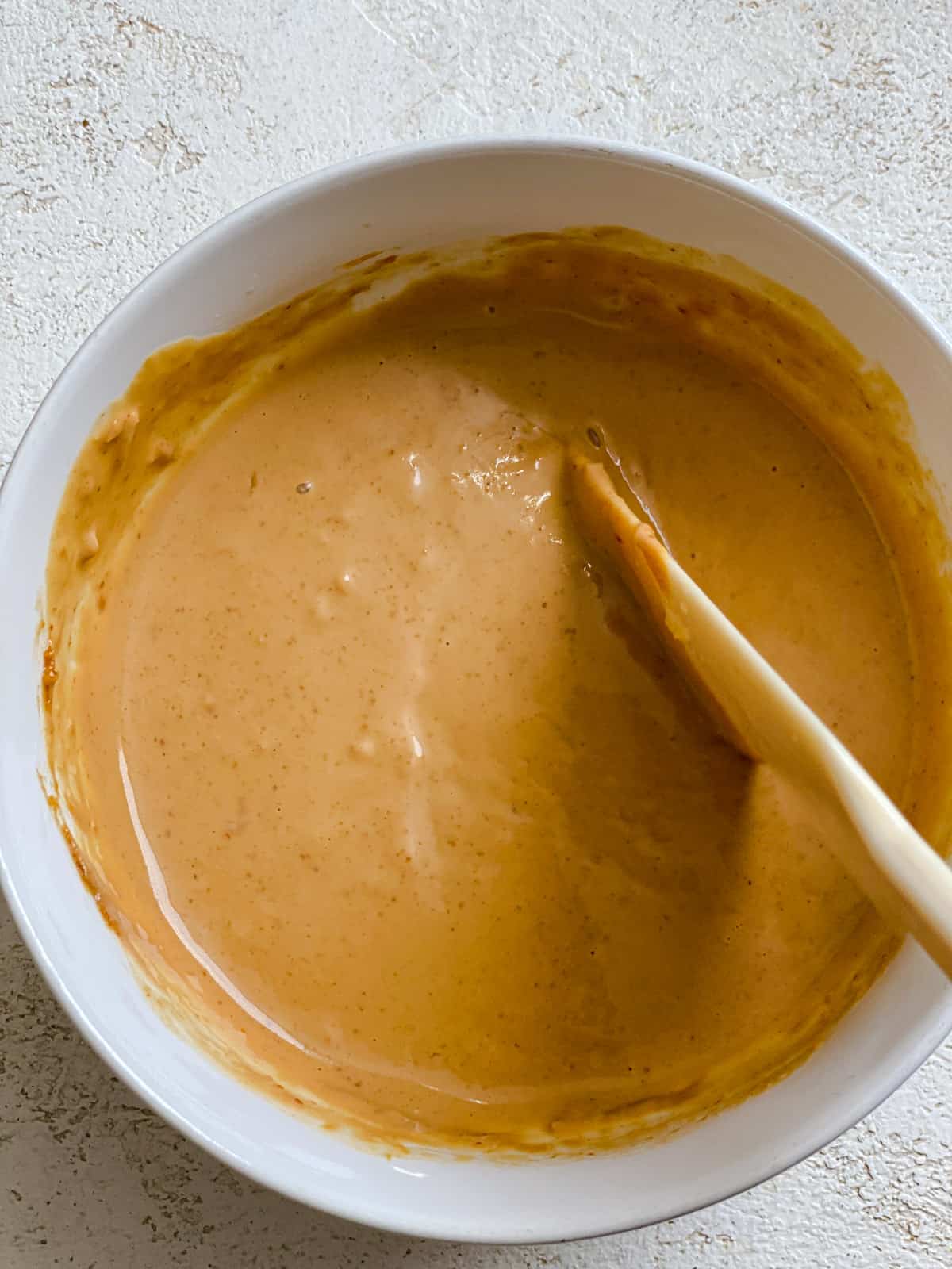 process shot of mixing ingredients together for peanut sauce in bowl