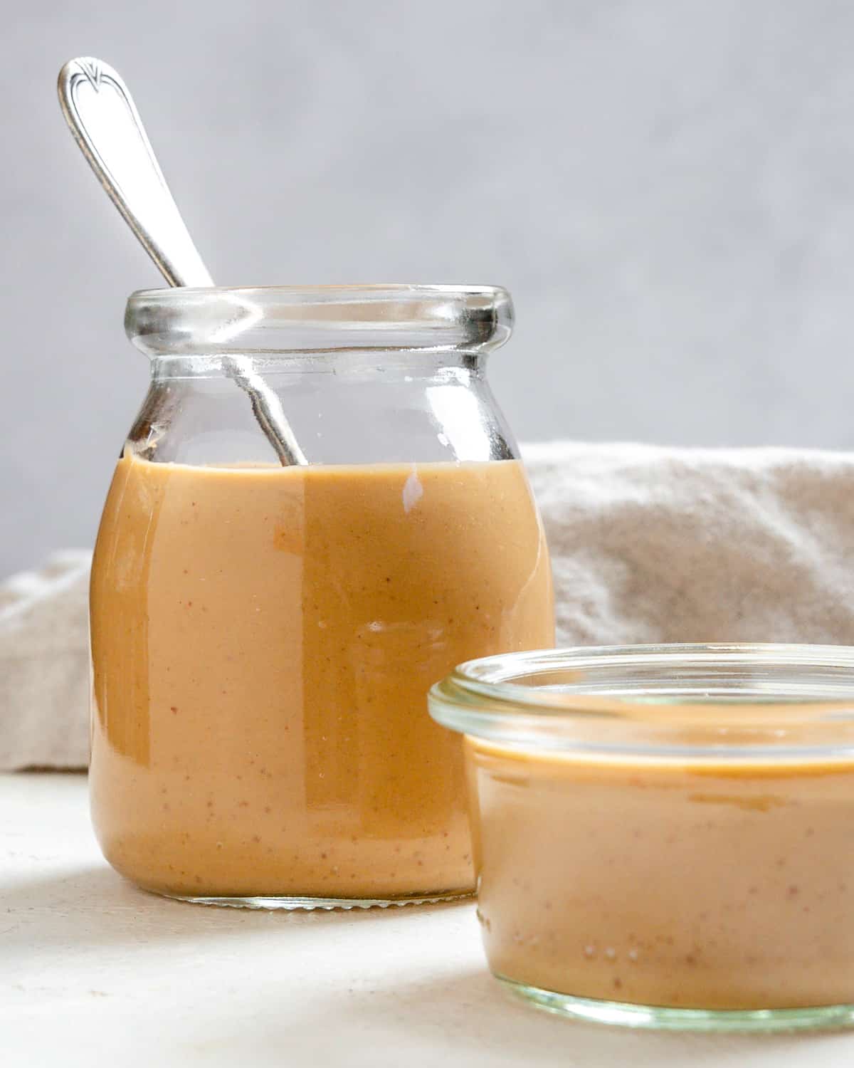 completed Spicy Peanut Dipping Sauce in two containers against a white background