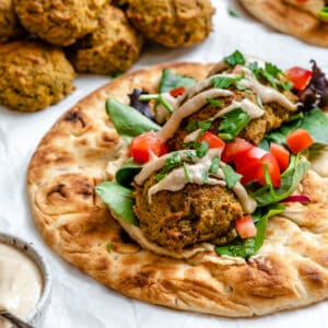 completed Healthy Baked Falafel on bread against a white background