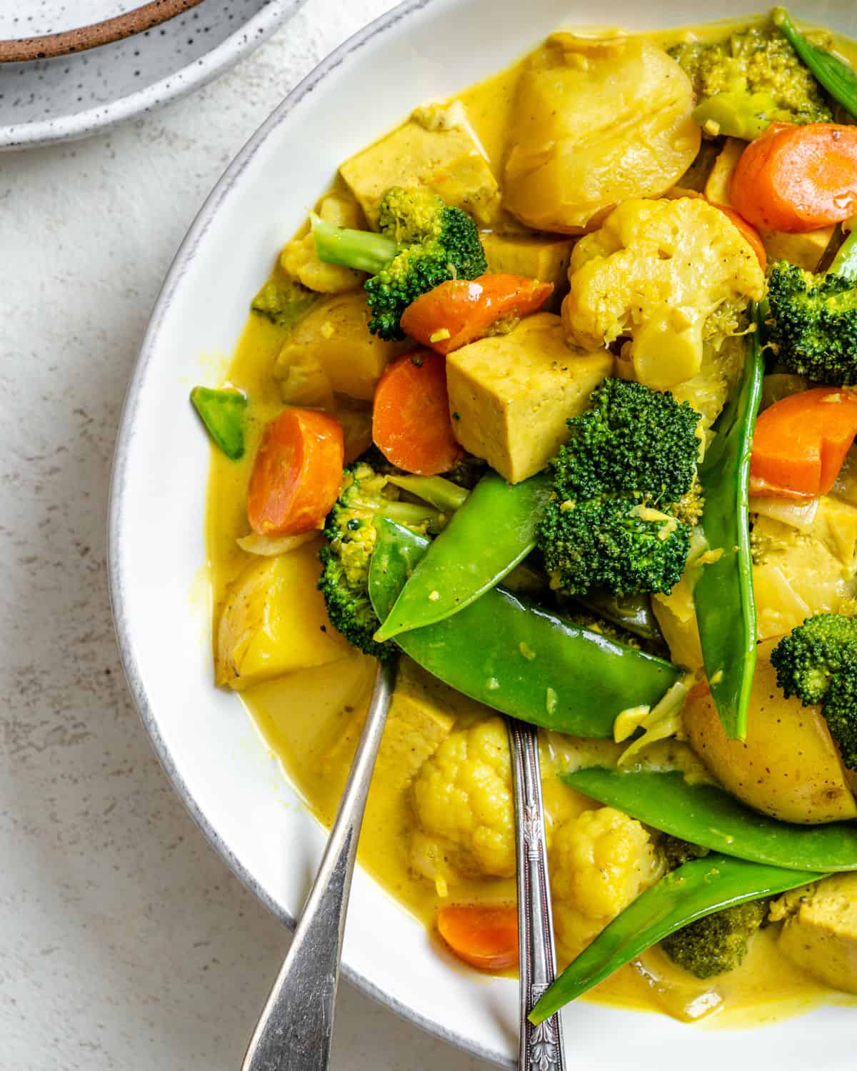 completed Easy Tofu Vegetable Coconut Curry in a bowl against a white background